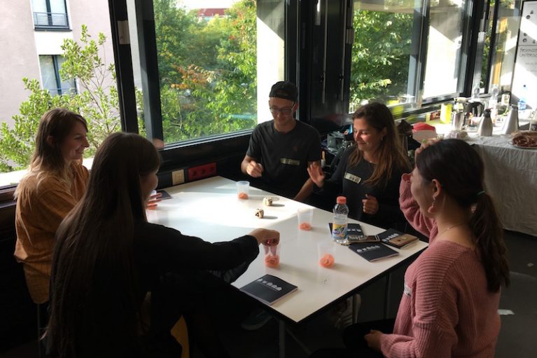 Austauschstudierende sitzen um einen Tisch